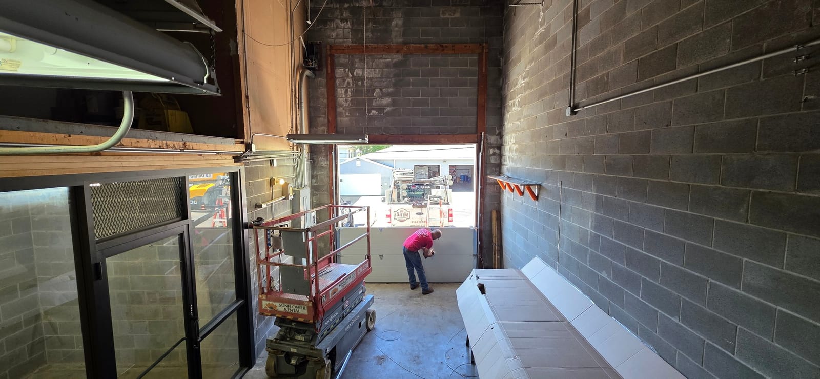 Technician fitting the bottom section of a commercial sectional door in Independence, MO