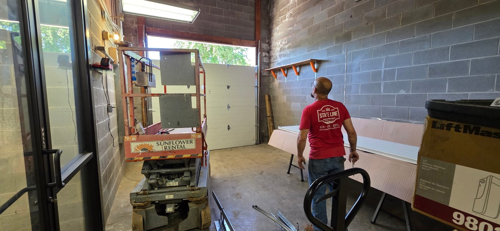 State Line technician checking a newly hung commercial sectional door in Independence, MO