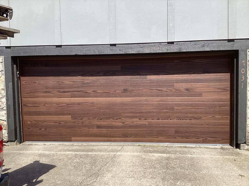 Walnut finish modern garage door installed in Harrisonville, MO