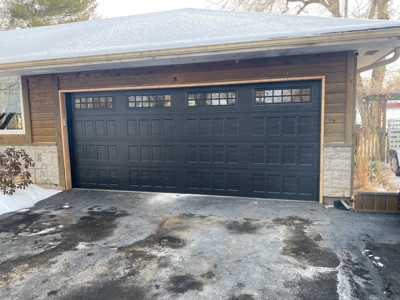 Black carriage style garage door installed on craftsman home in Kansas City