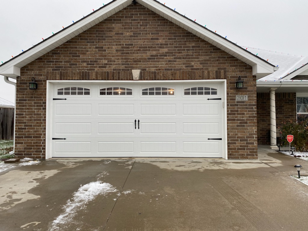Classic white carriage house garage door on brick home in Blue Springs, MO